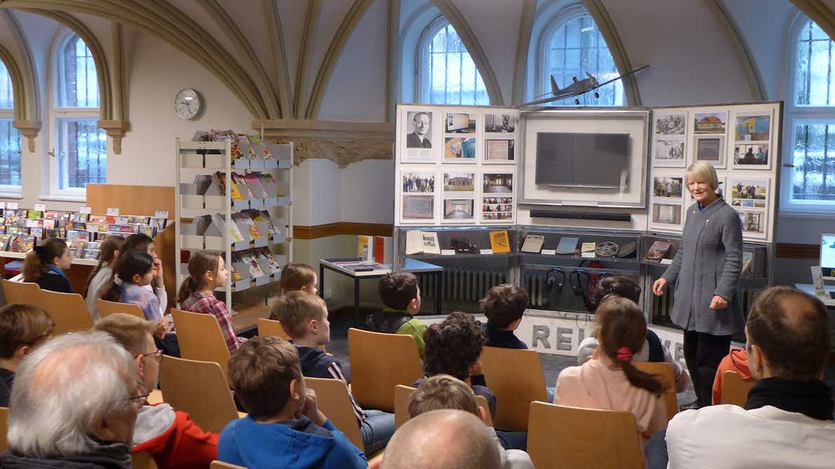Sabine Reichwein mit der Ausstellung über ihren Vater vor SchülerInnen in einer Bibliothek